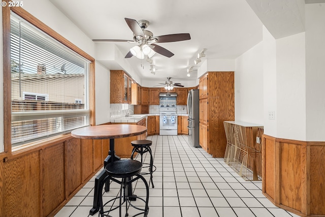 409 Pacific Ave, Brookings, OR 97415 - kitchen featuring freestanding refrigerator, white range with electric stovetop, brown cabinetry, ceiling fan, and a sink