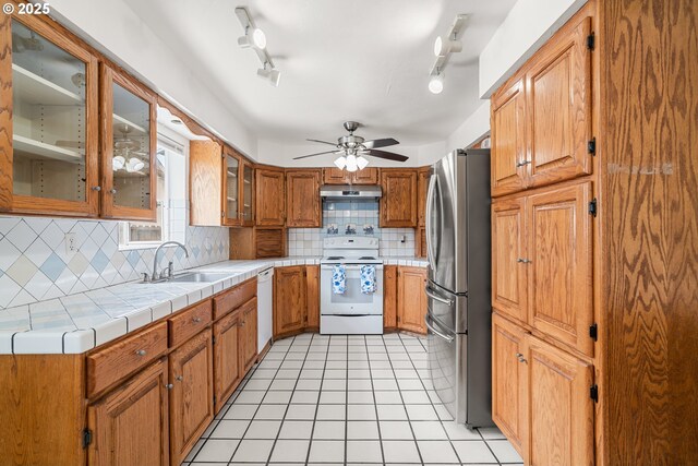 409 Pacific Ave, Brookings, OR 97415 - kitchen with white appliances, a sink, decorative backsplash, under cabinet range hood, and ceiling fan