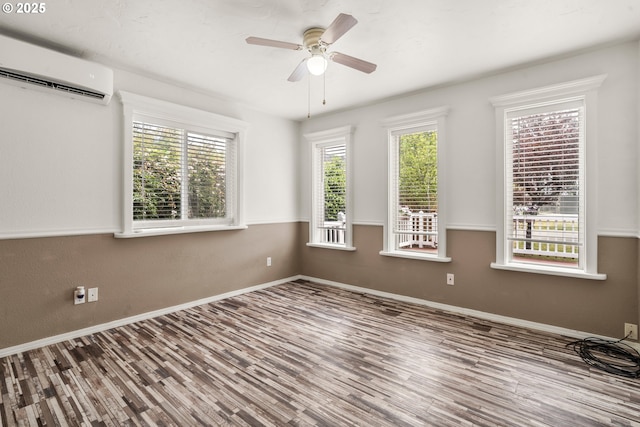 409 Pacific Ave, Brookings, OR 97415 - empty room with a wall mounted AC, wood finished floors, baseboards, and ceiling fan