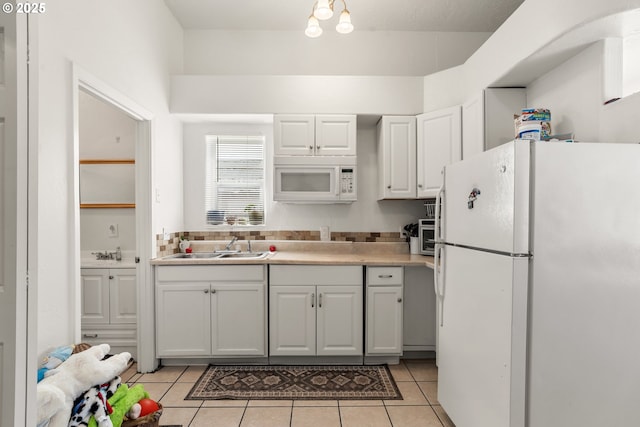 409 Pacific Ave, Brookings, OR 97415 - kitchen featuring white appliances, white cabinets, light tile patterned flooring, light countertops, and a sink