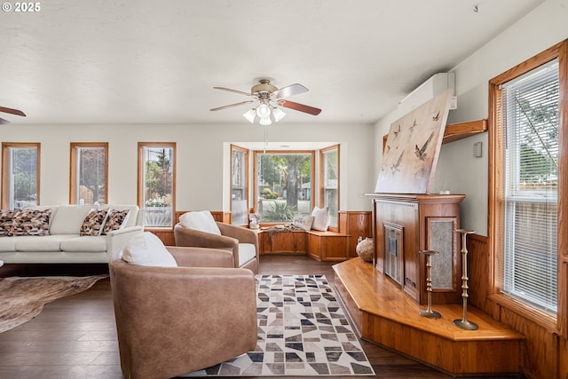 409 Pacific Ave, Brookings, OR 97415 - living area with ceiling fan, a wainscoted wall, wood finished floors, a premium fireplace, and wood walls