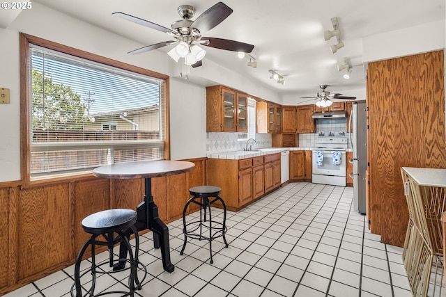 409 Pacific Ave, Brookings, OR 97415 - kitchen featuring white appliances, brown cabinetry, a ceiling fan, tasteful backsplash, and a sink
