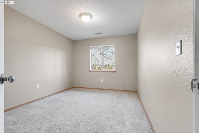 carpeted spare room with a textured ceiling