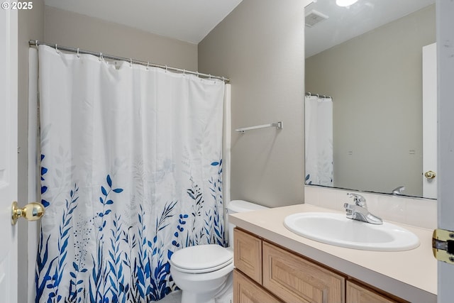 bathroom featuring vanity, curtained shower, and toilet