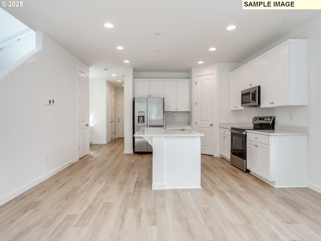 kitchen with stainless steel appliances, a sink, recessed lighting, light countertops, and white cabinetry