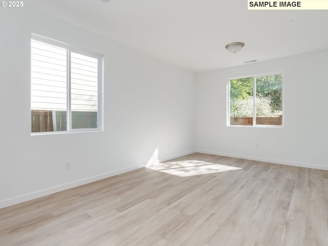 spare room with light wood-type flooring and baseboards