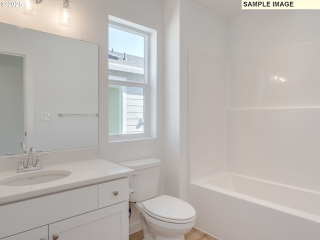 bathroom featuring toilet, vanity, and shower / washtub combination