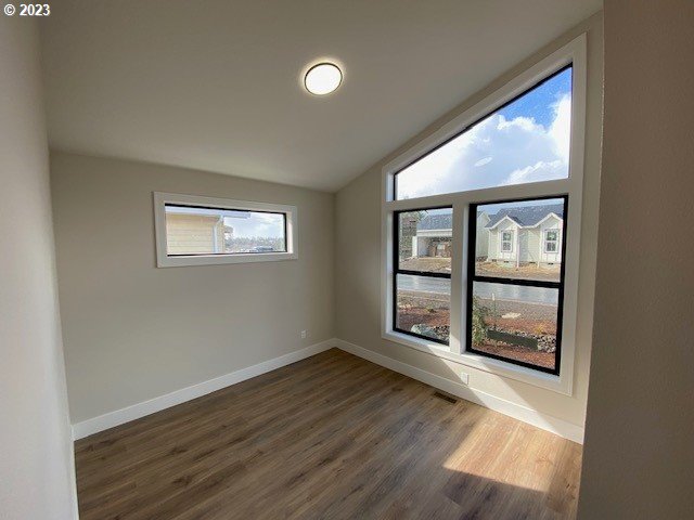 486 Meadows Dr, Manzanita, OR 97130 - empty room with dark wood finished floors and vaulted ceiling