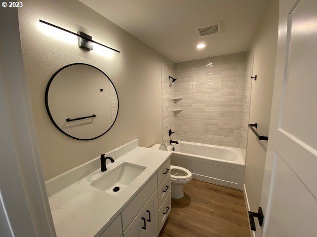 486 Meadows Dr, Manzanita, OR 97130 - bathroom featuring vanity, wood finished floors, shower / washtub combination, and recessed lighting