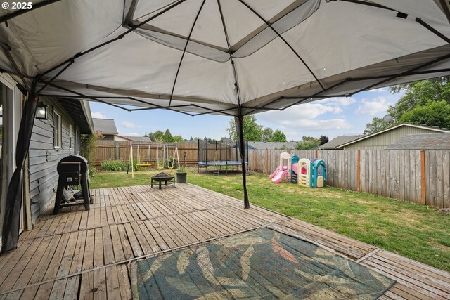 304 Frances St, Molalla, OR 97038 - deck with a trampoline, a fenced backyard, a grill, and a playground