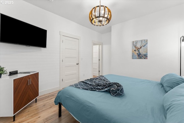 531 NW Vancouver Ave, Stevenson, WA 98648 - bedroom featuring light wood-type flooring, a chandelier, baseboards, and a closet