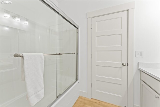 531 NW Vancouver Ave, Stevenson, WA 98648 - full bathroom with wood finished floors, vanity, and bath / shower combo with glass door