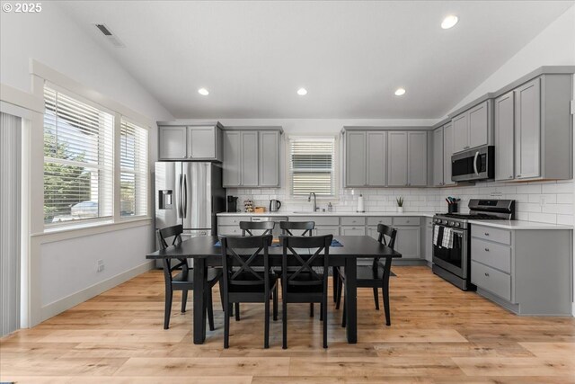 531 NW Vancouver Ave, Stevenson, WA 98648 - kitchen with gray cabinetry, appliances with stainless steel finishes, vaulted ceiling, backsplash, and light countertops