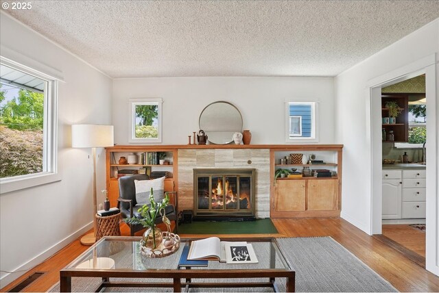 3615 NE 72nd Ave, Portland, OR 97213 - living room featuring wood finished floors, a tile fireplace, healthy amount of natural light, and a textured ceiling