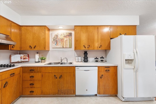 kitchen with white appliances, a sink, light countertops, brown cabinetry, and under cabinet range hood