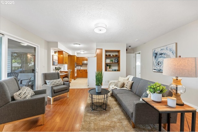 living area with light wood finished floors and a textured ceiling
