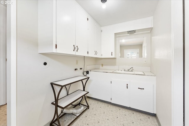 clothes washing area featuring cabinet space, light flooring, and washer hookup