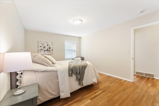 bedroom with wood finished floors and baseboards