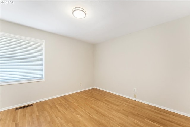 unfurnished room with light wood-type flooring and baseboards