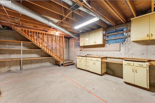 unfinished below grade area featuring a workshop area and stairs
