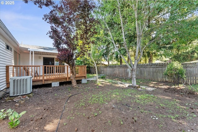 fenced backyard featuring a deck and central AC