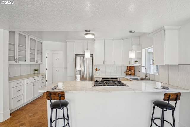 1952 SE 139th Ave, Portland, OR 97233 - kitchen featuring stainless steel refrigerator with ice dispenser, a sink, a peninsula, white cabinetry, and a textured ceiling
