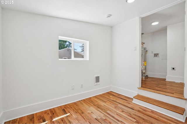 1952 SE 139th Ave, Portland, OR 97233 - empty room featuring secured water heater, heating unit, light wood-style flooring, recessed lighting, and baseboards