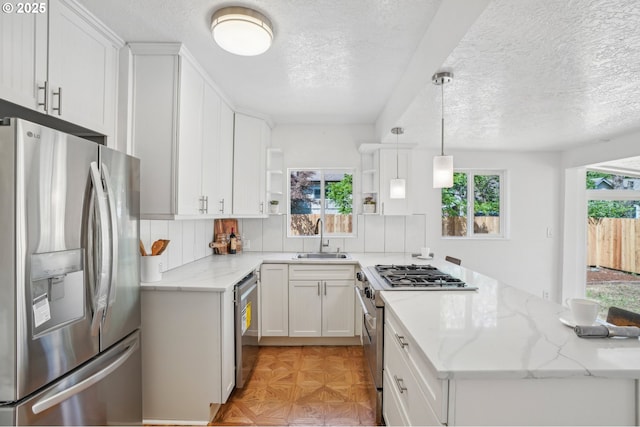 1952 SE 139th Ave, Portland, OR 97233 - kitchen featuring appliances with stainless steel finishes, a sink, open shelves, a textured ceiling, and white cabinetry