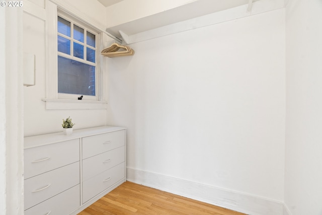 walk in closet with light wood-style flooring