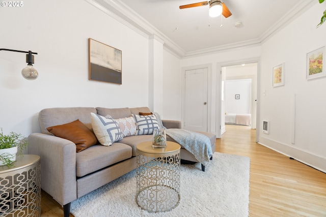 living area with ceiling fan, baseboards, wood finished floors, and crown molding