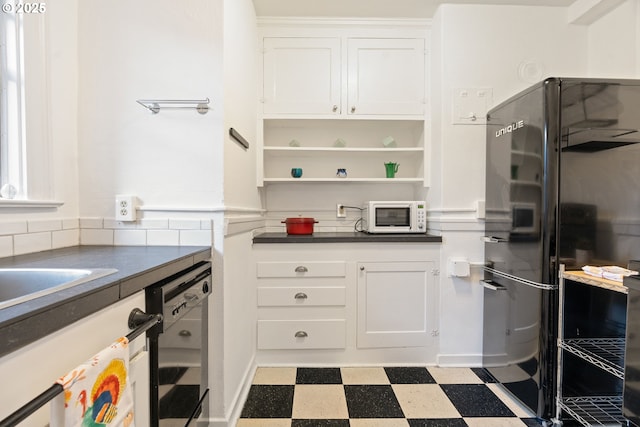 kitchen featuring dark countertops, tile patterned floors, black appliances, white cabinetry, and open shelves