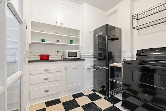 kitchen featuring light floors, open shelves, white cabinetry, black appliances, and dark countertops