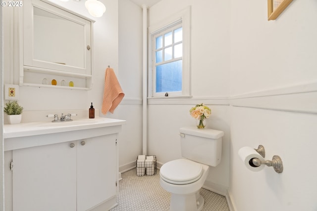 bathroom featuring tile patterned flooring, baseboards, vanity, and toilet