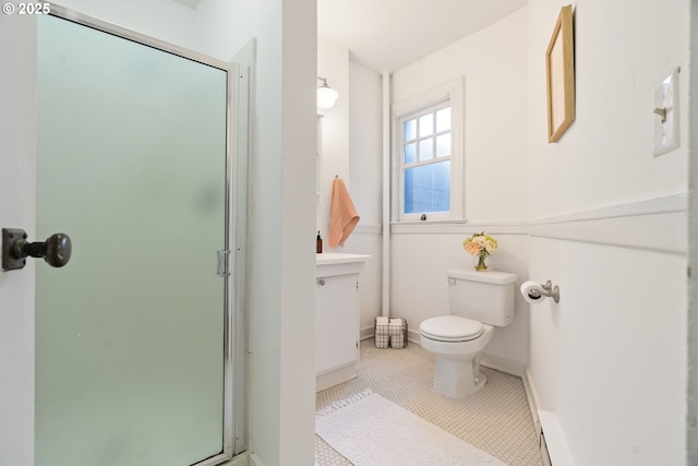 bathroom with toilet, a shower stall, baseboards, and tile patterned floors