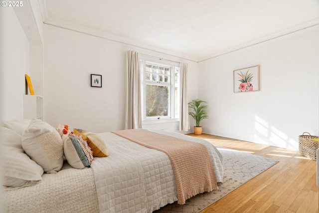 bedroom featuring wood-type flooring and crown molding