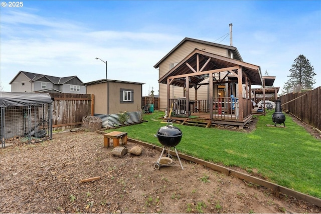 rear view of property with a storage shed, a yard, and a wooden deck