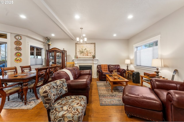 living room featuring beamed ceiling, a chandelier, and hardwood / wood-style flooring