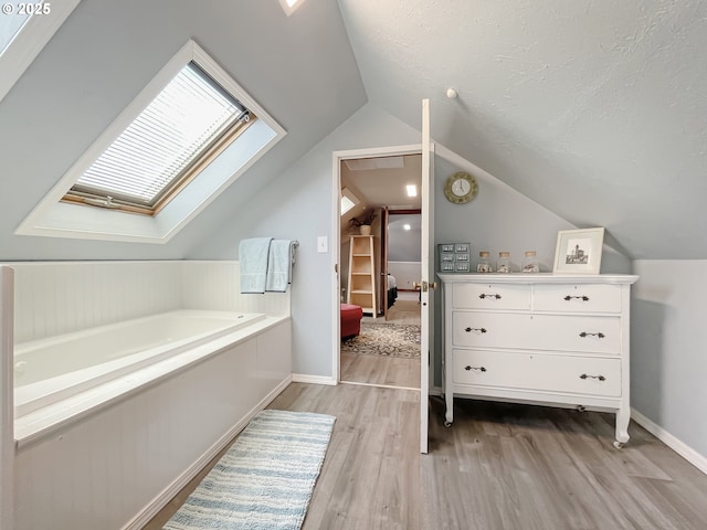 97994 W Benham Ln, Brookings, OR 97415 - additional living space featuring light wood-style floors, vaulted ceiling, baseboards, a skylight, and a textured ceiling