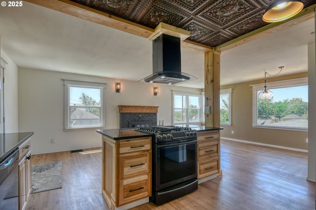 501 NW 6th St, Pendleton, OR 97801 - kitchen with black gas range, wall chimney exhaust hood, dark countertops, and dishwasher