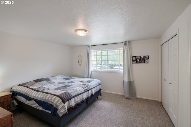 bedroom with carpet, a closet, baseboards, and a textured ceiling