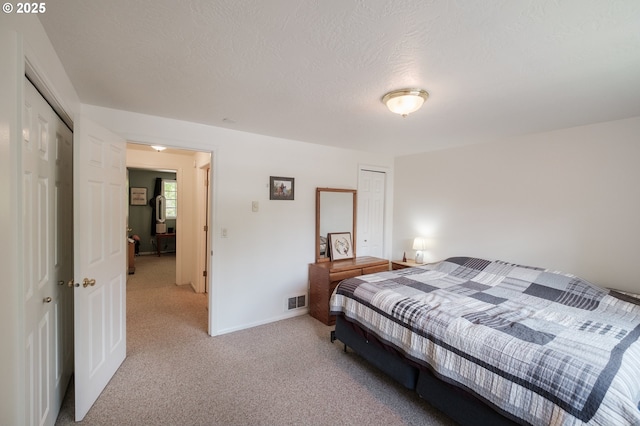 carpeted bedroom with a closet and baseboards