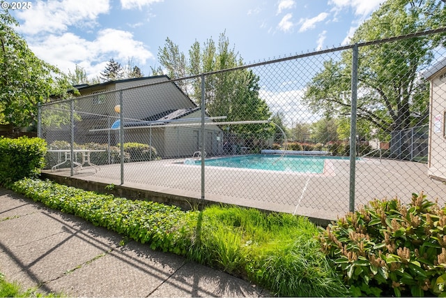 community pool with fence and a patio area