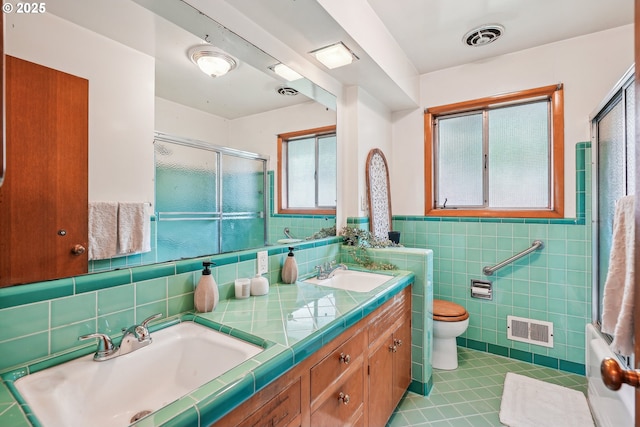5955 NE 32nd Ave, Portland, OR 97211 - full bath with tile walls, tile patterned floors, visible vents, and a sink