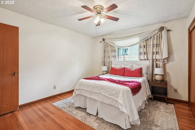 5955 NE 32nd Ave, Portland, OR 97211 - bedroom featuring a textured ceiling, baseboards, a ceiling fan, and wood finished floors