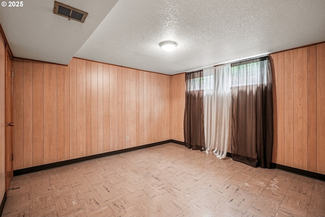 5955 NE 32nd Ave, Portland, OR 97211 - empty room featuring wooden walls, a textured ceiling, and baseboards