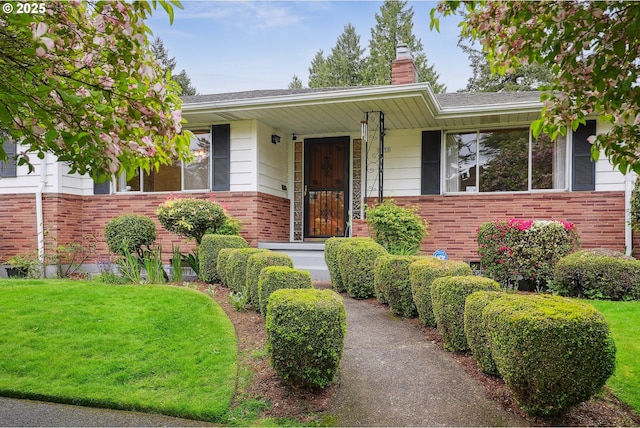 5955 NE 32nd Ave, Portland, OR 97211 - view of front of house featuring a chimney, a front lawn, and brick siding