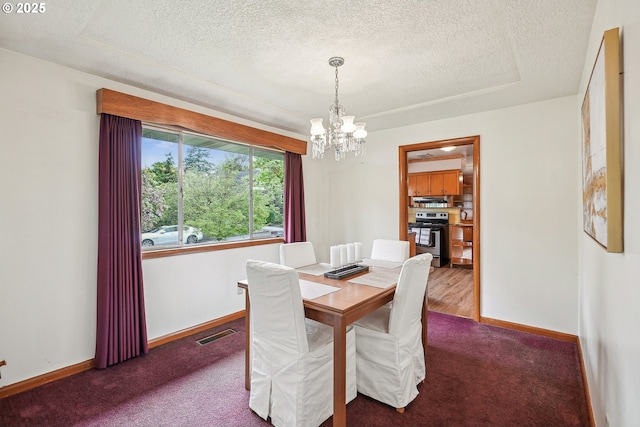 5955 NE 32nd Ave, Portland, OR 97211 - dining space with a notable chandelier, a textured ceiling, baseboards, dark colored carpet, and visible vents