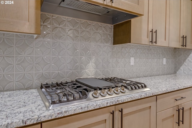 kitchen with decorative backsplash, light brown cabinetry, stainless steel gas stovetop, and custom exhaust hood