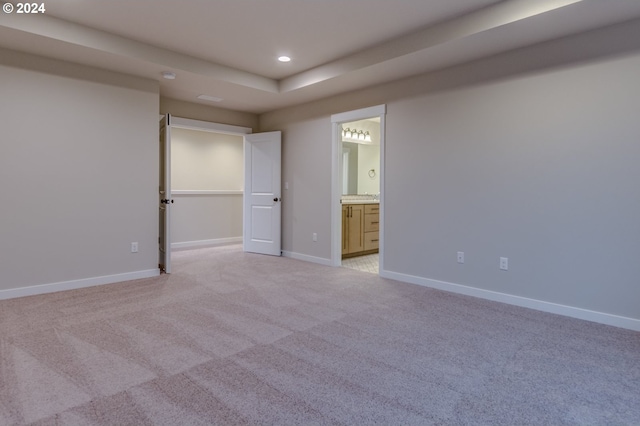 unfurnished bedroom with connected bathroom and light colored carpet