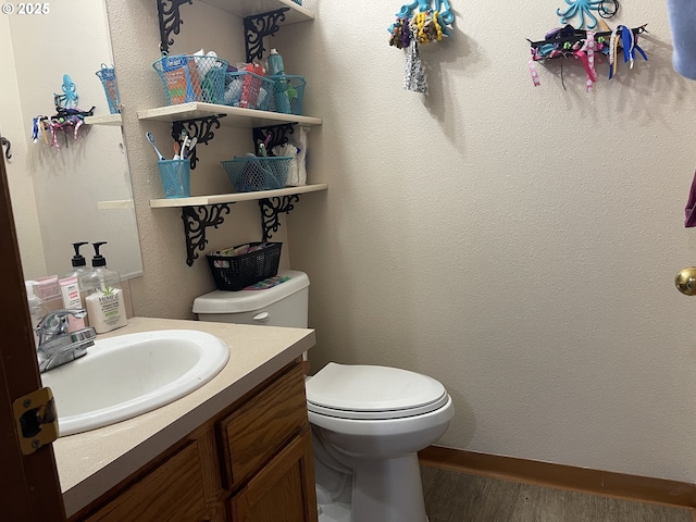 bathroom with vanity, hardwood / wood-style floors, and toilet